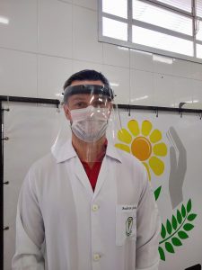 Técnico da área de saúde da APAE Bauru utilizando o escudo facial, juntamente com as demais EPIs: a máscara cirúrgica e jaleco